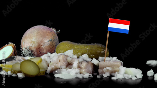 Dutch traditional salted herring in a studio setting with onions  and pickles