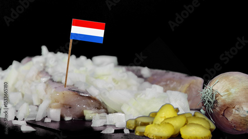 Dutch traditional salted herring in a studio setting with onions  and pickles