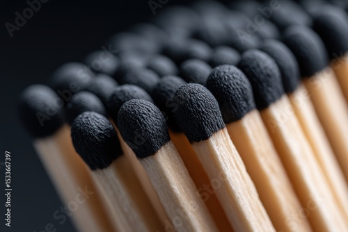 Close-up view of matchsticks with striking black tips, showcasing texture and detail in a minimalist setting.