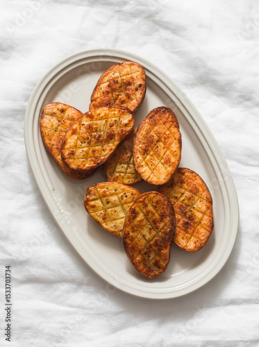 Barbecue potatoes - delicious appetizer, tapas, lunch on a light background, top view
