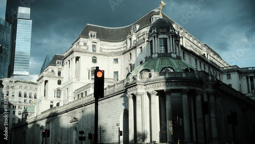 A large white building with a clock on it ' s side the scene features  under moody and dramatic conditions.
