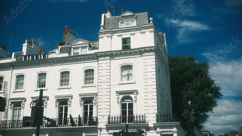 A large white building with a clock on the top of it the scene features  under moody and dramatic conditions.