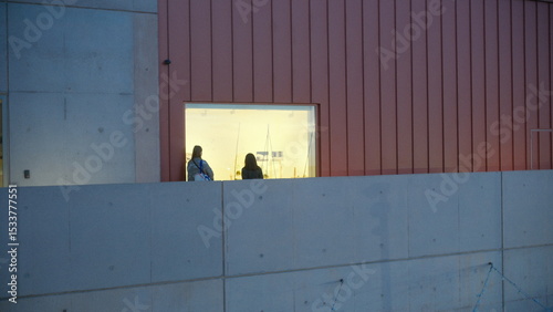 A highly detailed, professional photograph of a man and a woman sitting on a wall captured with artistic lighting and excellent composition. the scene features  under moody and dramatic conditions.