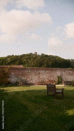 A view of a grassy field with a house in the background the scene features  under moody and dramatic conditions.
