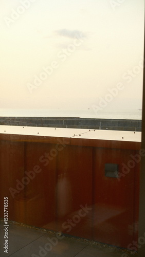 A white toilet sitting in a bathroom next to a red wall the scene features  under moody and dramatic conditions.