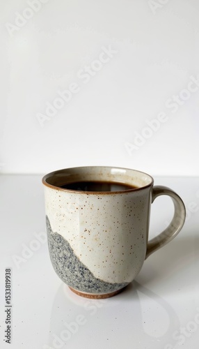 Handcrafted ceramic mug with mountain design filled with coffee  