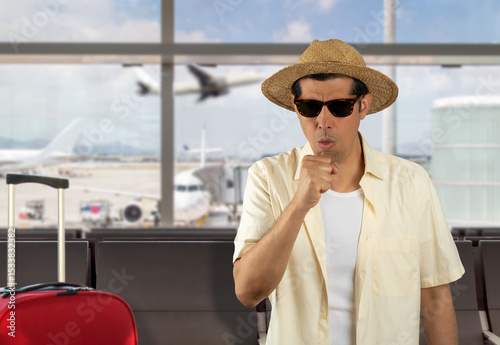 Man on vacation wearing yellow shirt hat sunglasses at airport.Feeling unwell and coughing as symptom for cold or bronchitis. Healthcare concept.