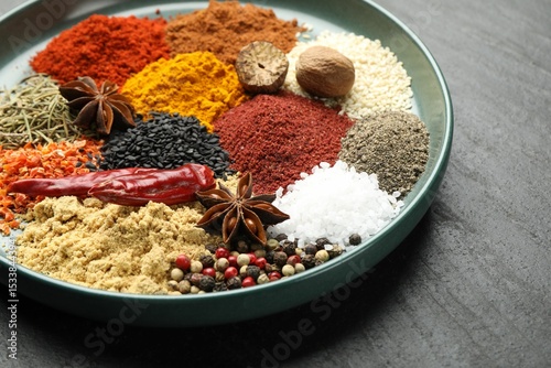 Fototapeta Naklejka Na Ścianę i Meble -  Different aromatic spices on dark textured table, closeup