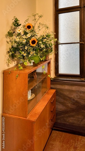 A bouquet of wildflowers in a vase. Wildflowers in an old house. A bouquet of wildflowers and sunflowers. A concept of old times and romance
