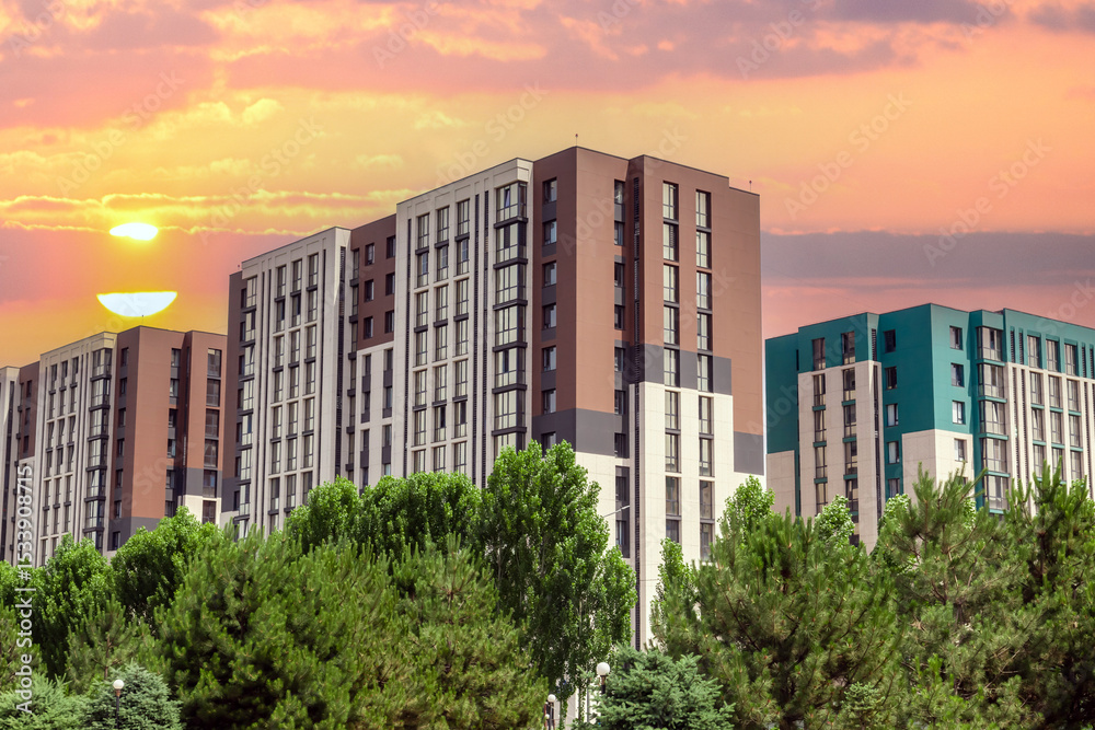 Fototapeta premium Large apartment building with a green roof and a tree in front of it