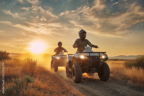 two men riding all terrain vehicles on dusty trail during golden sunset with scenic hills and dramatic cloudy sky in background photo