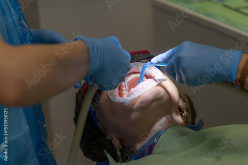 Dentist performs procedure on patient in dental clinic