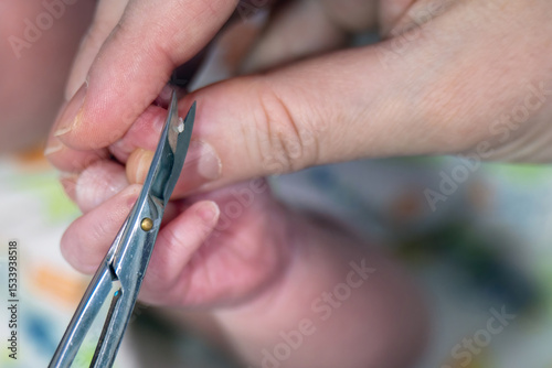 Delicate newborn nail trimming with precision scissors, capturing a tender baby care moment