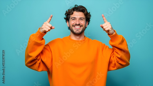 A man is joyfully pointing upwards with his fingers while wearing a big smile on his face, radiating happiness and positivity