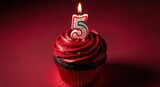 Red frosted cupcake with lit number 5 candle for birthday or anniversary celebration