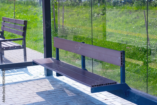 A beautifully crafted wooden bench sits conveniently in front of a glass wall