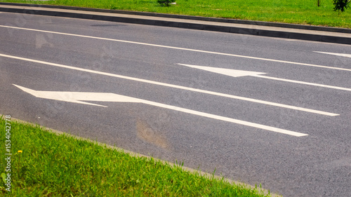 A road with two distinct white arrows clearly painted on its surface