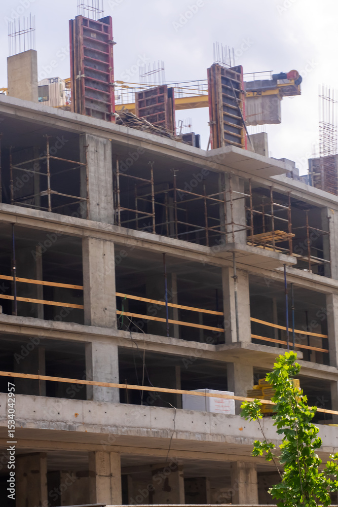 Fototapeta premium A large building being constructed with a crane in the background