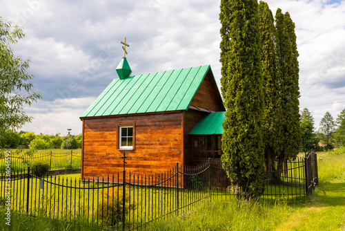 Small wooden Orthodox chapel with green roof in Polish countryside, Poland.