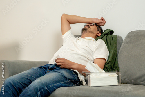 Ill male lying in bed at home, recovering from illness and resting during the day