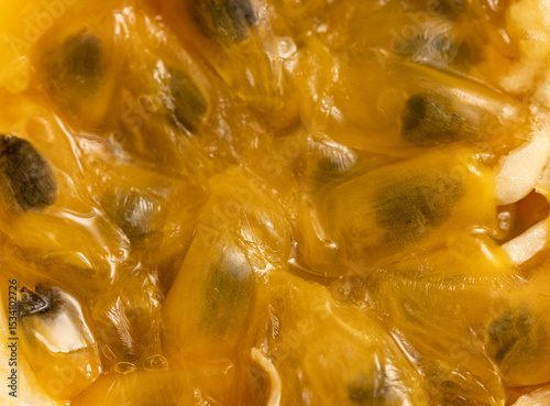 A close up of a yellow fruit with black seeds