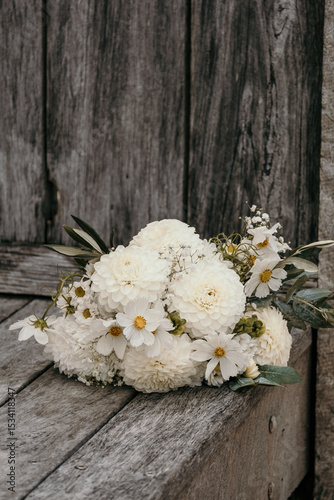White wedding bouquet laid on decking.