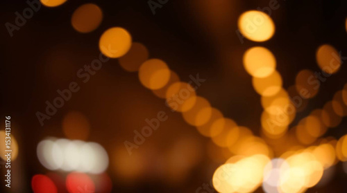 Blurry lights in a dark background creating a bokeh effect with orange and yellow circular lights