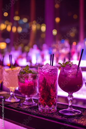 Colorful cocktails arranged on a bar counter with vibrant lighting in a lively venue during the evening
