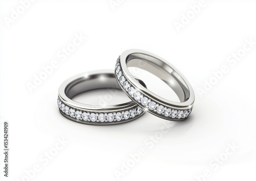 Close up of two silver wedding bands adorned with diamonds on a white background studio shot