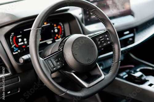 Concept of stylish design, shopping, and car parts. Close-up of a car steering wheel in a modern new car. The interior of a stylish new car. 