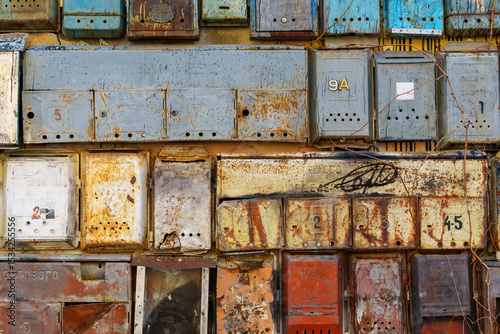 group of old mailboxes on the wall of a building, old weathered paint