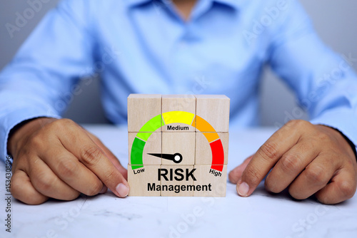 Risk management concept with businessman arrange wooden block to reduce risk level in the business and manage problems correctly and precisely