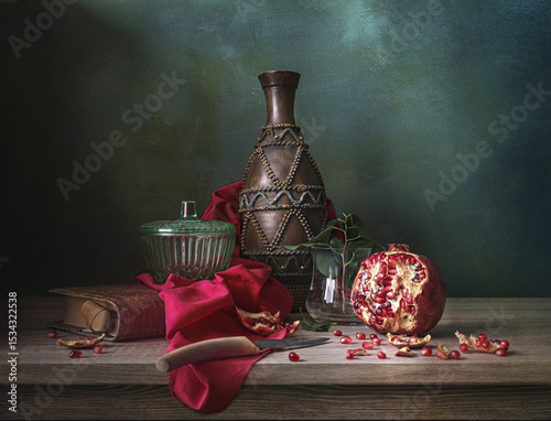still life with a pomegranate on a green background