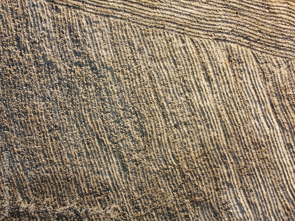 Fototapeta premium Patterns of sand created by tide changes on a beach in the early morning light