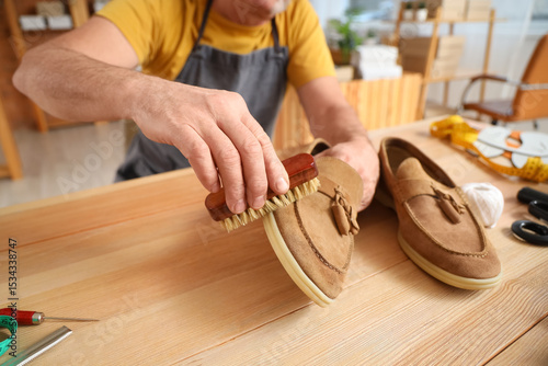 Mature shoemaker brushing s...