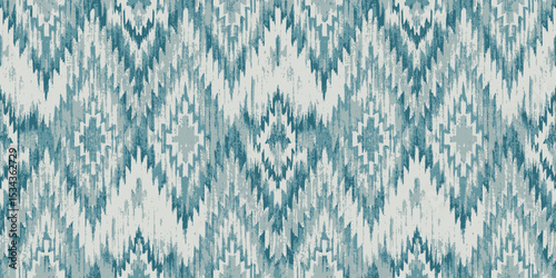 Stylish teal and white ikat pattern with angular geometric shapes.