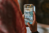 Muslim woman photographing the green dome of the prophet's mosque with smartphone