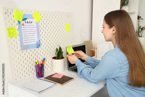 Young woman making to-do li...
