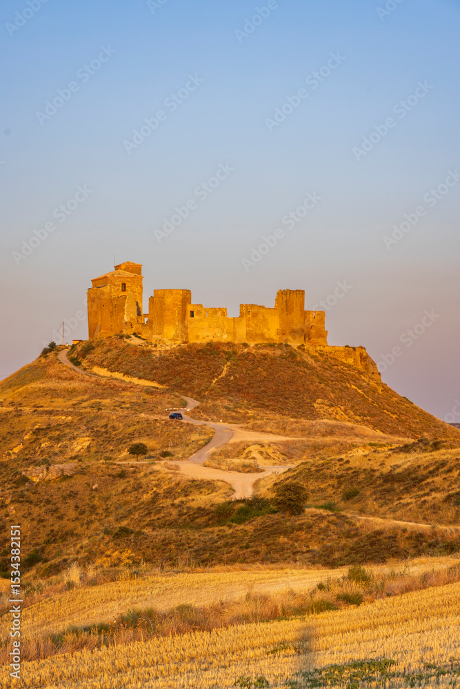 Obraz premium Castillo de Montearagon standing tall on a hill in Quicena, Spain, during golden hour