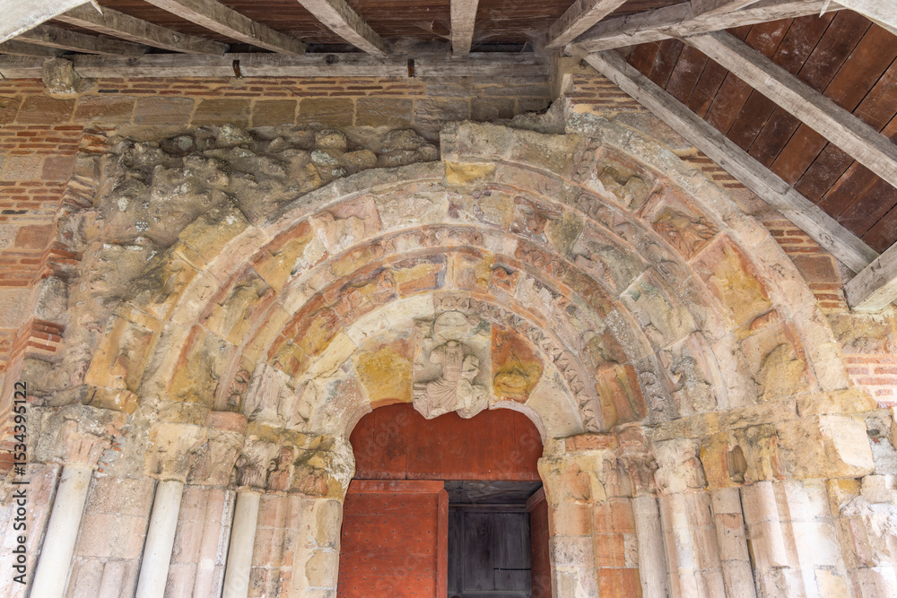 Fototapeta premium Ancient portal of the Saint Jean Baptiste abbey church showing weathered sculptures in Sorde l'Abbaye, France