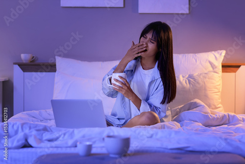 Sleepy young woman with cof...