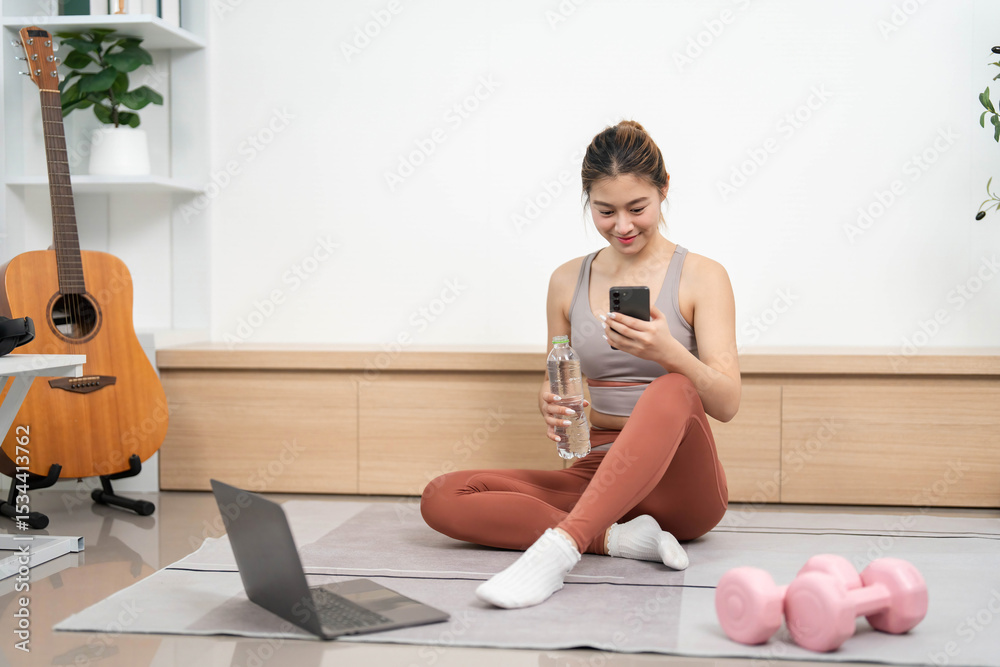 Obraz premium Yoga and Digital Connection. Young woman engaging with smartphone while practicing yoga.
