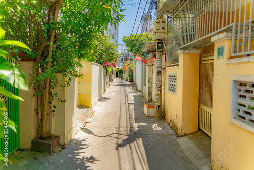 Fototapeta Naklejka Na Ścianę i Meble -  The streets of a small town.

Vietnamese neighborhoods of Nha Trang city in Vietnam. Narrow small streets with low-rise apartment buildings. 