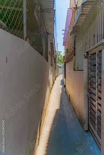 Fototapeta Naklejka Na Ścianę i Meble -  The streets of a small town.

Vietnamese neighborhoods of Nha Trang city in Vietnam. Narrow small streets with low-rise apartment buildings. 