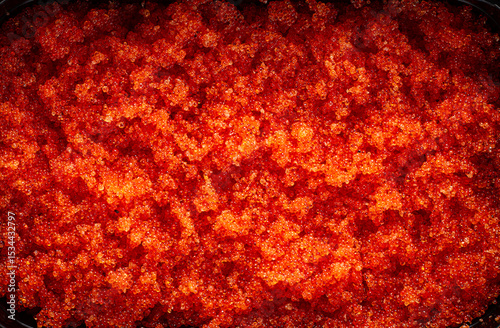 container with orange caviar, flying fish, Tobiko, on the table, caviar for rolls and sushi, close-up,