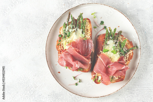 open sandwiches with asparagus and prosciutto, with cheese, breakfast, on a plate,