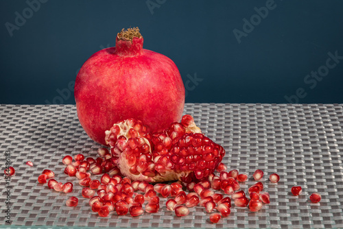 Fresh pomegranate fruit and grains on the table photo