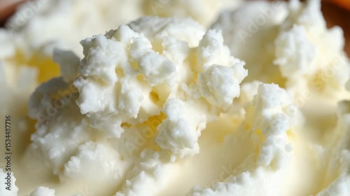 Close-up view of creamy cottage cheese texture, highlighting lumpy surface, smooth edges, and white, soft food details.