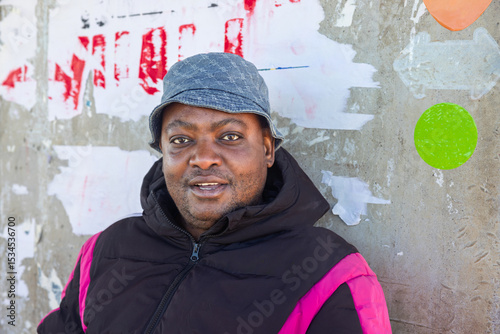 village african man traveler in the bus station waiting, wearing a hat