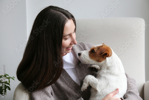 Young woman relaxing at home with her dog. Copy space, background.